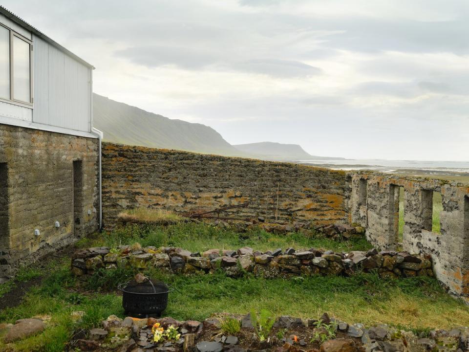 Quaint walled garden on the grounds of the renovated barn uses the original structure's stone walls as row dividers.