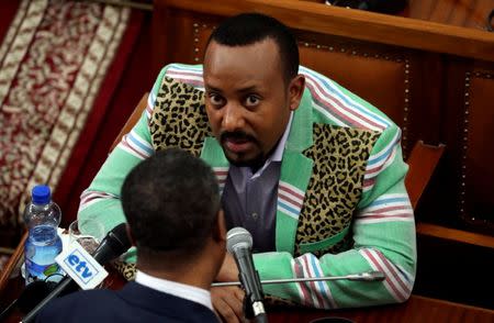 FILE PHOTO: Ethiopia's Prime Minister Abiy Ahmed talks to an unidentified legislator inside the House of Peoples' Representatives in Addis Ababa, Ethiopia October 25, 2018. REUTERS/Tiksa Negeri