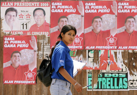 IMAGEN DE ARCHIVO. Una mujer peruana camina frente a propaganda del candidato a la presidencia Alan García, en Lima. 8 de abril de 2006. REUTERS/Mariana Bazo