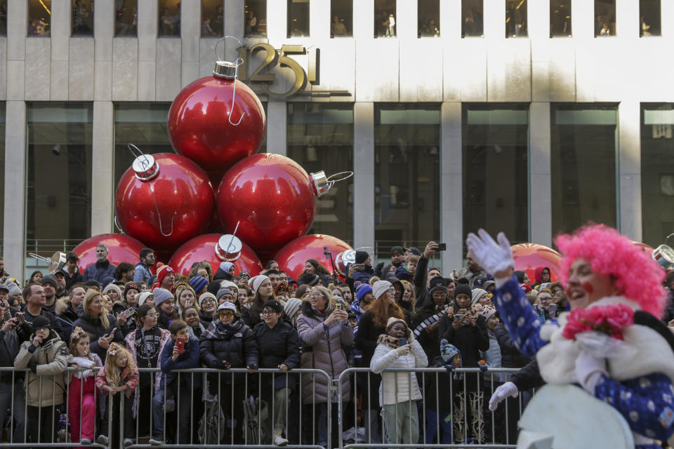 Spectators line Sixth Avenue as they watch clowns, floats and balloons go by during the Macy's Thanksgiving Day Parade, Thursday, Nov. 24, 2022, in New York. (AP Photo/Jeenah Moon)