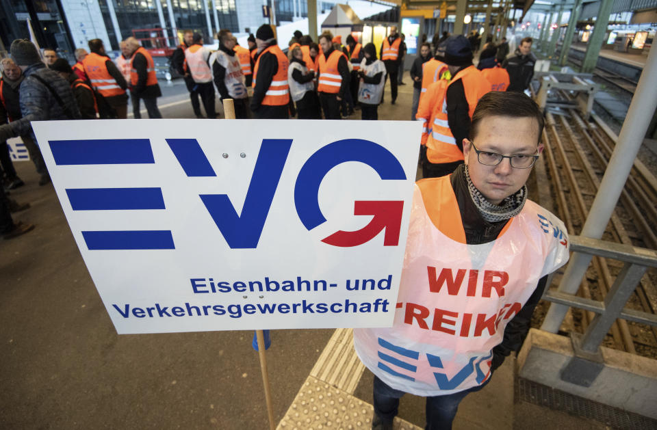 A picketer holds a poster of the train workers union at the main station in Stuttgart, southern Germany, Monday, Dec. 10, 2018. Thousands of commuters were hit by a German-wide strike. (Marijan Murat/dpa via AP)