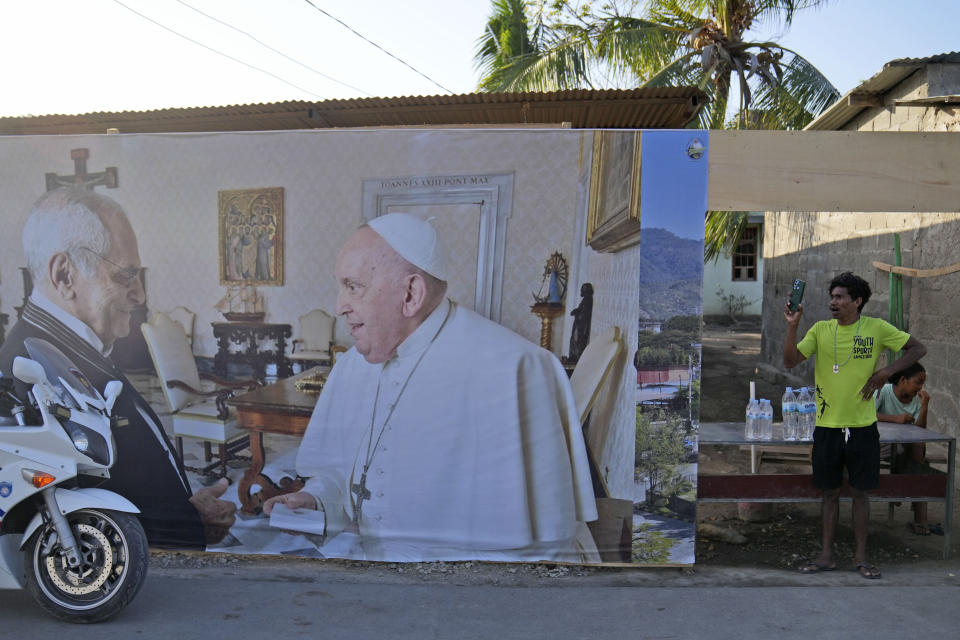 A man stands near a banner showing East Timor's President Jose Ramos-Horta, left, shaking hands with Pope Francis, ahead of the pope's visit to the country, in Dili, Saturday, Sept. 7, 2024. (AP Photo/Dita Alangkara)