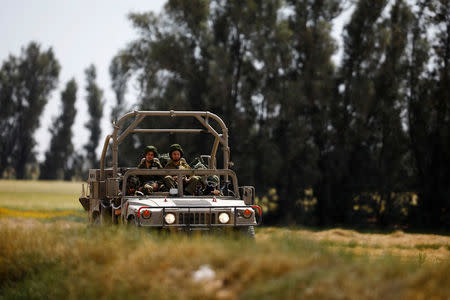 Israeli soldiers drive a military vehicle near the border between Israel and the Gaza Strip, Israel March 18, 2018. REUTERS/Amir Cohen