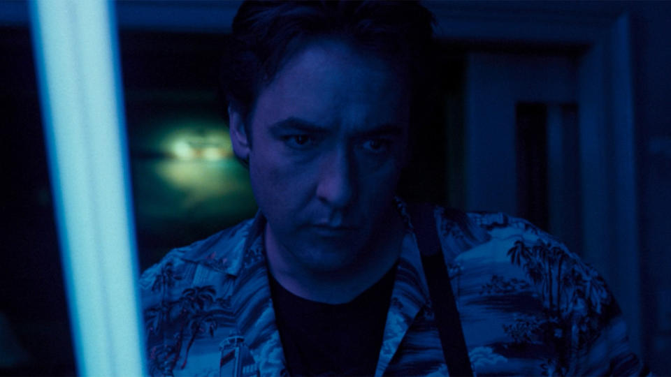 John Cusack holding a blacklight in 1408