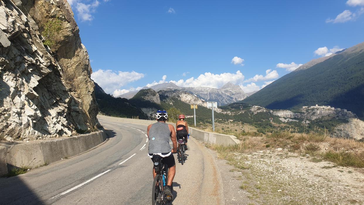 People cycling on a road on a mountain