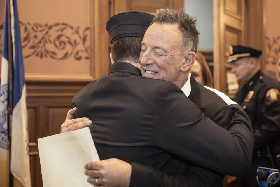 In this photo provided by the Jersey City Mayor's Office, Bruce Springsteen hugs his son Sam Springsteen after he is sworn in as a Jersey City Firefighter at City Hall in Jersey City, N.J. on Tuesday, Jan. 14, 2020. (Jennifer Brown/Jersey City Mayor's Office via AP)