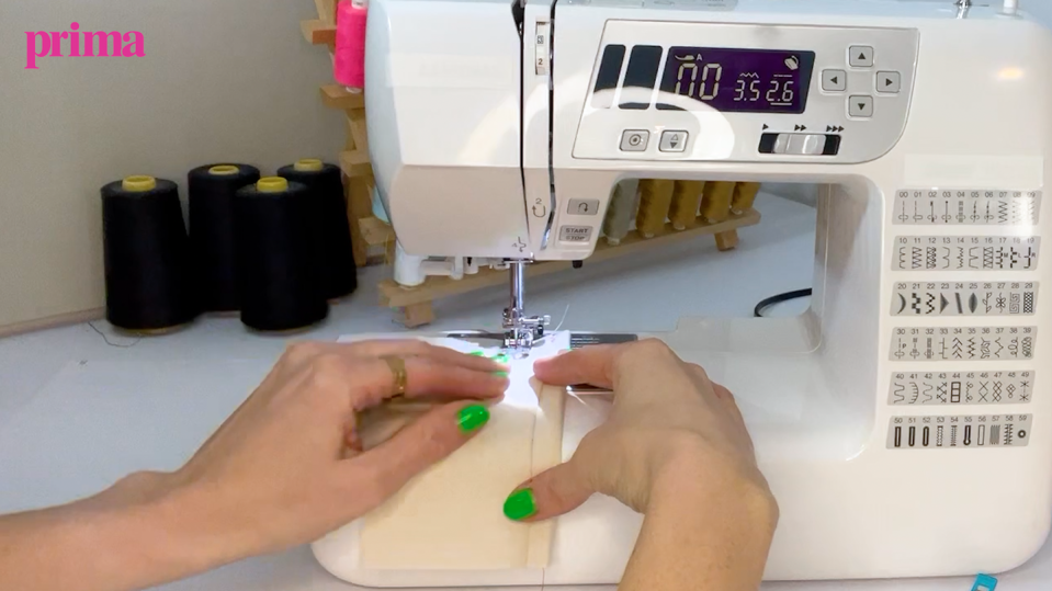 hands on a piece of fabric on a sewing machine