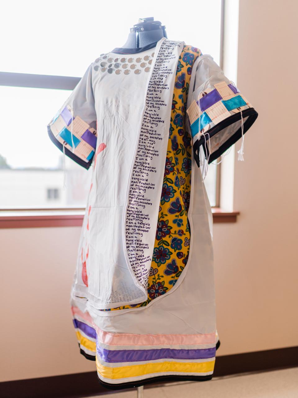 Researcher Abigail Echo-Hawk created a dress out of a body bag, one of several sent to her outpatient clinic early on in the pandemic. The dress honors the many disproportionate losses Native Americans experience, from COVID-19 to violence. Written across the dress is the phrase: "I am the tangible manifestation of my ancestors resiliency."