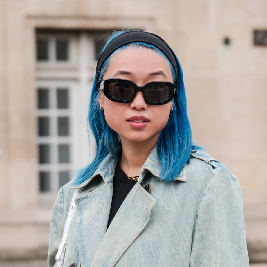 Margaret Zhang wears light blue denim long trench coat, black sunglasses, outside Balenciaga, during the Womenswear Fall/Winter 2024/2025 as part of Paris Fashion Week on March 03, 2024 in Paris, France.