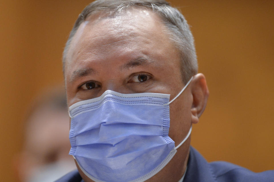 Romanian Prime Minister designate Nicolae Ciuca wears a mask before a parliament vote on his government team in Bucharest, Romania, Thursday, Nov. 25, 2021. Romanian lawmakers voted in favor of a new coalition government led by a Liberal former army general, which could usher in an end to a months-long political crisis in the Eastern European nation.(AP Photo/Alexandru Dobre)