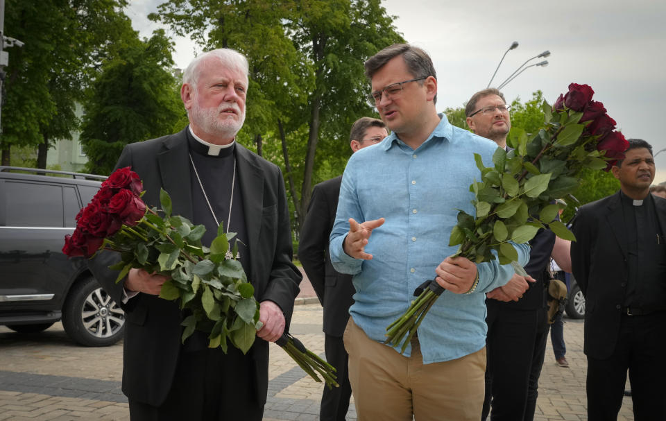 Ukrainian Foreign Minister Dmytro Kuleba, right, and Vatican Secretary for Relations with States Archbishop Paul Richard Gallagher lay flowers at the Memorial Wall of Fallen Defenders of Ukraine in Russian-Ukrainian War in Kyiv, Ukraine, Friday, May 20, 2022. (AP Photo/Efrem Lukatsky)