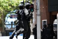 Members of the police tactical unit deploy near the cafe