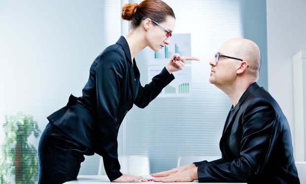 business woman pointing out a business man reproaching him at work in an office