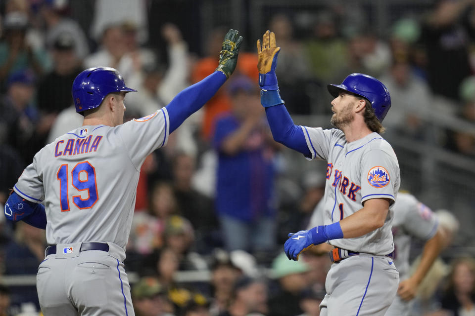 New York Mets' Jeff McNeil, right, reacts with teammate Mark Canha after scoring from second off an RBI-single by Francisco Alvarez during the tenth inning of a baseball game against the San Diego Padres, Friday, July 7, 2023, in San Diego. (AP Photo/Gregory Bull)