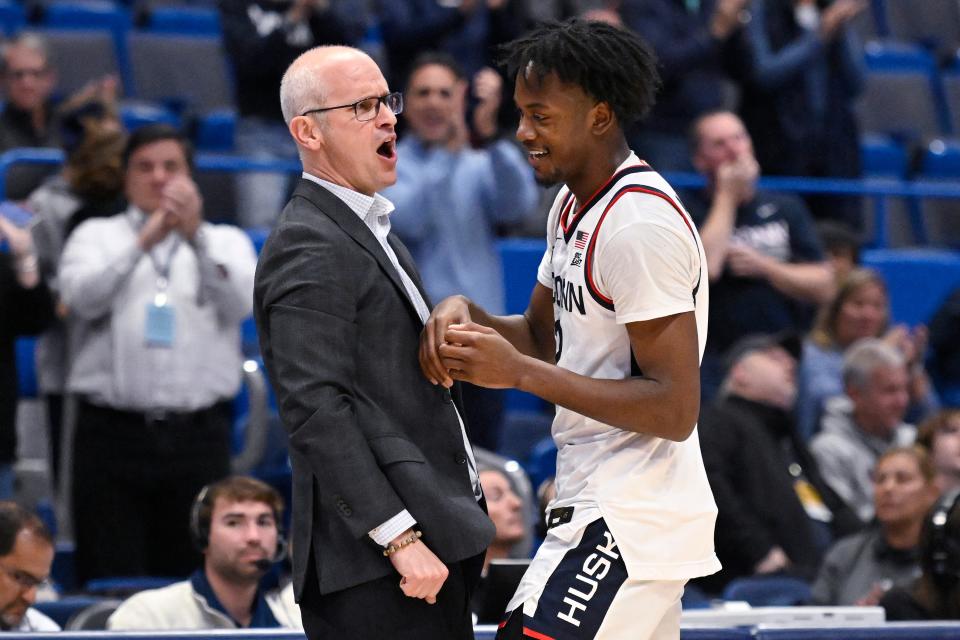 Connecticut head coach Dan Hurley celebrates with Connecticut's Tristen Newton (2) after Newton came out of the with a triple double in the second half of an NCAA college basketball game against Buffalo, Tuesday, Nov. 15, 2022, in Hartford, Conn. (AP Photo/Jessica Hill)