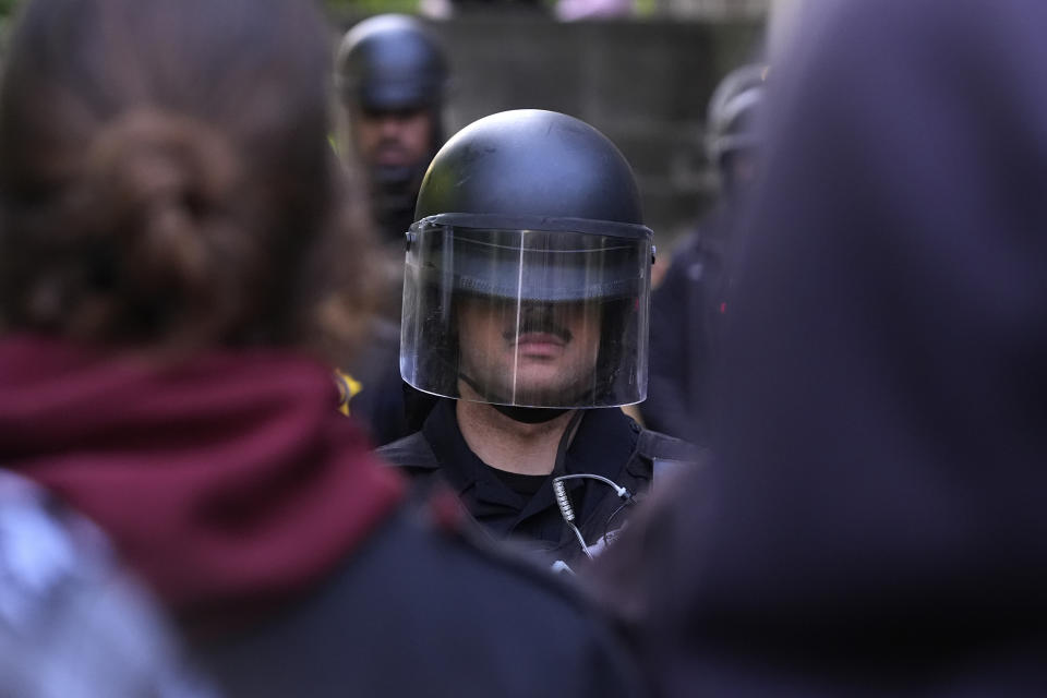 A police officer stands guard blocking pro-Palestinian protesters from returning to their encampment as the encampment is dismantled at the University of Chicago, Tuesday, May 7, 2024. (AP Photo/Charles Rex Arbogast)