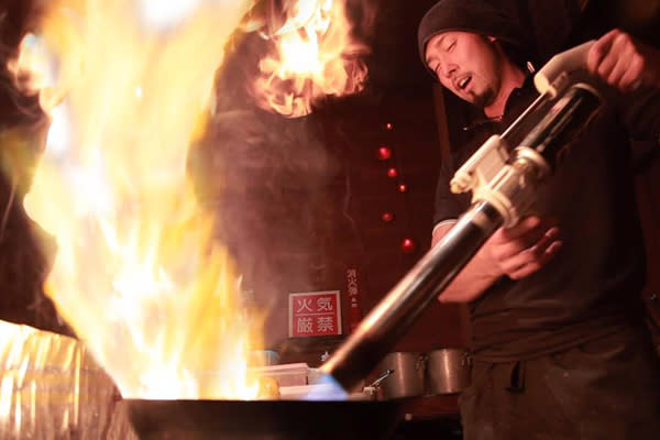 以1300度火焰槍噴射高溫火焰烹煮拉麵。(圖片來源 / 札幌炎神拉麵　台灣店)