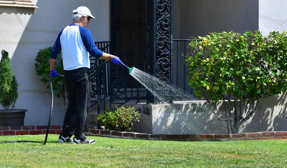 In this file photo taken on April 27, 2022 a man waters his lawn in Alhambra, California, a day after Southern California declared a water shortage emergency, with unprecedented new restrictions on outdoor watering for millions of people living in Los Angeles, San Bernardino and Ventura counties.