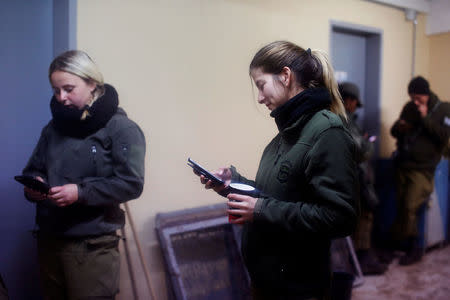 Female Israeli soldiers from the Haraam artillery battalion use their mobile phones as they stand in the women's living quarters at a military base in the Israeli-occupied Golan Heights March 1, 2017. REUTERS/Nir Elias