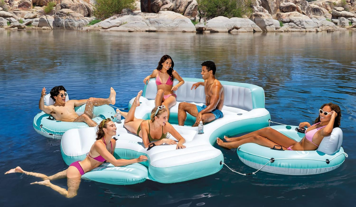 six swimmers lounging on a multi-part float in the water