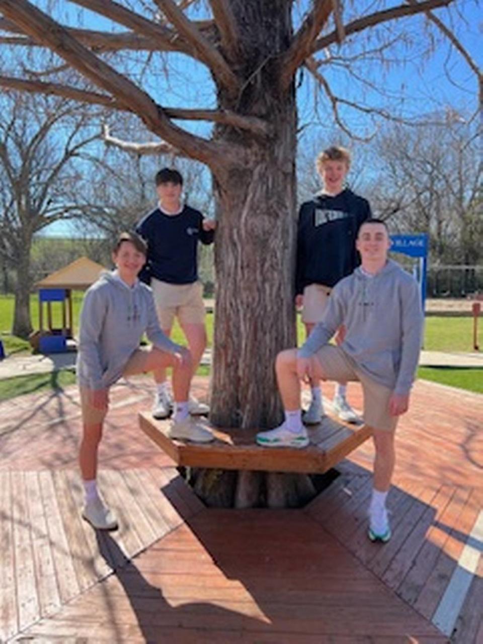 From left, Connor Karazissis, Brady McGraw, Austin Jones, and Evan Krum standing next to one of the many oak trees at The Oakridge School.