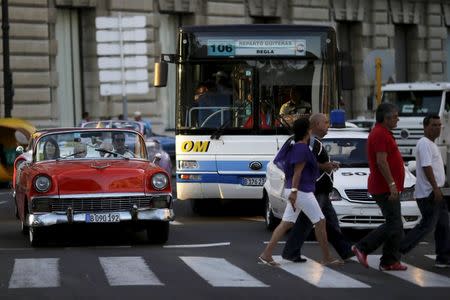 Foreign visitors ride in a vintage car in the afternoon traffic in Havana March 16, 2016. REUTERS/Ueslei Marcelino