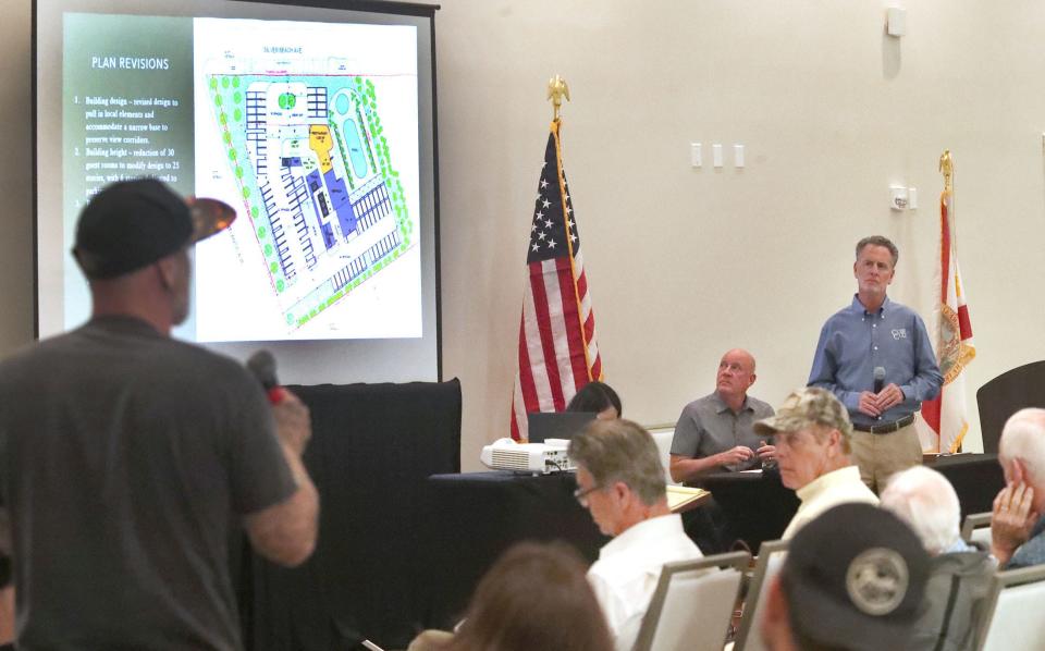 Rob Merrell, standing on the right, a land-use attorney with Cobb Cole Law Firm, listens to area residents' concerns regarding his client's revised plans to build a 25-story oceanfront luxury condo-hotel at the east end of Silver Beach Avenue in Daytona Beach at a developer-initiated neighborhood meeting at the Daytona Grande on Tuesday evening.