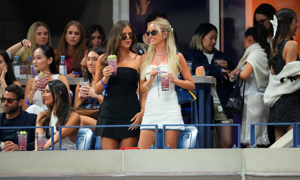 <span>Morgan Riddle, in white, drinks a Honey Deuce, the US Open’s $23 signature cocktail, on Tuesday inside Arthur Ashe Stadium.</span><span>Photograph: Gotham/GC Images</span>