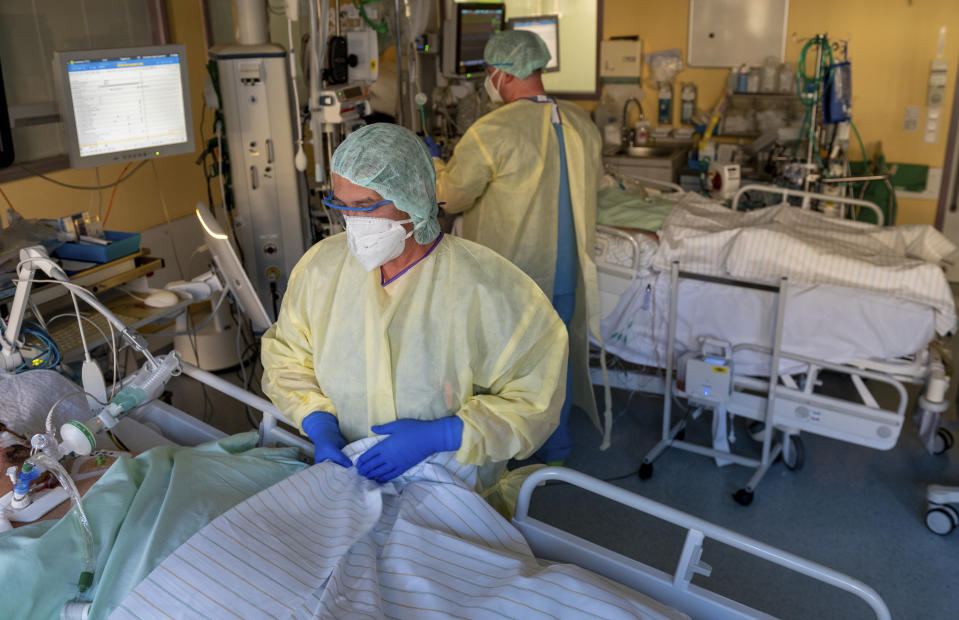 Intensive care nurses treat patients severely ill with Covid-19 disease in the Corona intensive care unit at the University Hospital in Halle/Saale on Monday, Nov. 22, 2021. The German air force Luftwaffe will begin assisting the transfer of intensive care patients from hospitals in Bavaria to northern German states.(Hendrik Schmidt/dpa via AP)