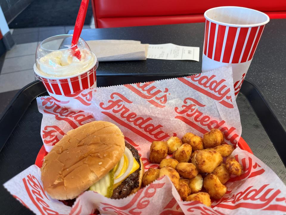 A meal of a double cheese steakburger, cheese curds, frozen vanilla custard and a soft drink waits to be consumed at the Freddy’s on Bearden Hill, which opened in the late fall of 2023.