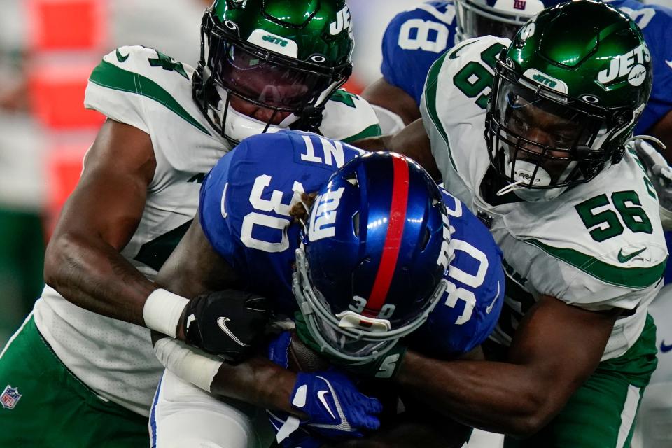 New York Giants running back Corey Clement (30) is tackled by New York Jets linebacker Noah Dawkins (56) and linebacker Jamien Sherwood, left, in the first half of an NFL preseason football game, Saturday, Aug. 14, 2021, in East Rutherford, N.J. (AP Photo/Frank Franklin II)