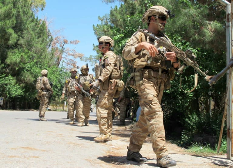 Afghan soldiers walk at the scene of clashes between Afghan security forces and Taliban militants in Helmand province on May 13, 2015