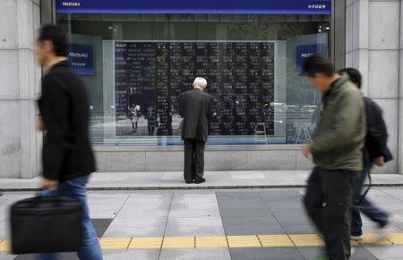 A man looks at a stock quotation board outside a brokerage in Tokyo, Japan, April 18, 2016. REUTERS/Toru Hanai