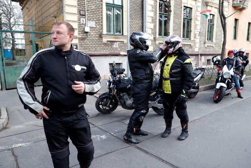 Members of the 'Easy Riders', a Hungarian bikers group, talk as they help a domestic violence victim in Budapest