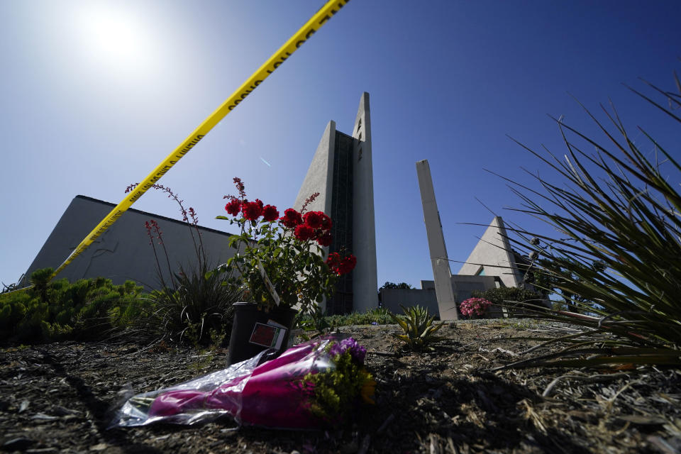 FILE - Flowers sit outside crime scene tape at Geneva Presbyterian Church on May 17, 2022, in Laguna Woods, Calif., where a shooting at the church on Sunday left one dead and five injured. Officials in California's Orange County are still trying to determine why a gunman opened fire in the church. (AP Photo/Ashley Landis, FILE)