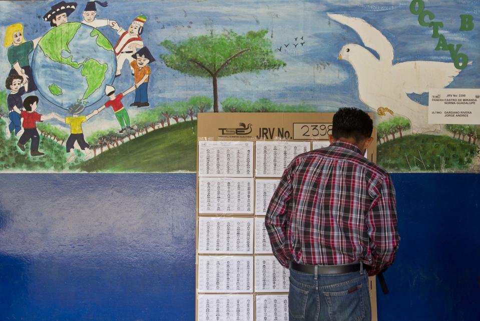 Un hombre busca su nombre en el registro electoral para ubicar su mesa de votación en la localidad de Panchimalco, El Salvador, el domingo 2 de febrero de 2014. Los salvadoreños eligirán un nuevo presidente. (AP foto/Esteban Felix)