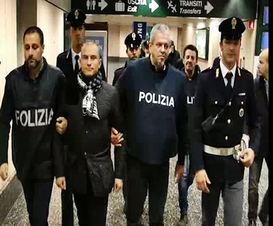In this frame grab from a video released by the Italian Police, Serbian footballer Almir Gegic, who has been wanted since June 2011 for alleged involvement in a widespread match-fixing case, is escorted by police after he arrived at the Malpensa airport in the outskirts of Milan, Italy, Monday evening, Nov. 26, 2012. After more than a year on the run, Gegic turned himself in and was brought to a jail in Cremona, where prosecutor Roberto Di Martino's match-fixing inquiry is based. More than 50 people have been arrested so far and more than 100 are under investigation. (AP Photo/Italian Police, HO)