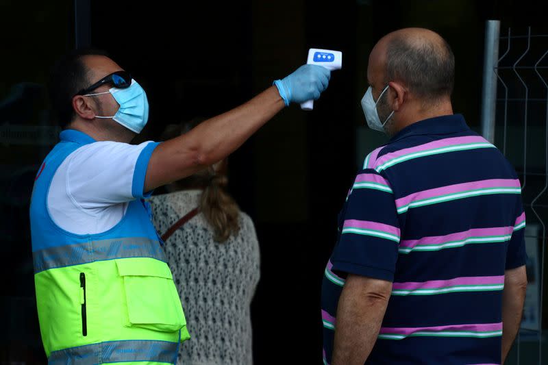 FILE PHOTO: A man gets his temperature checked before a coronavirus disease (COVID-19) antigen test in Madrid