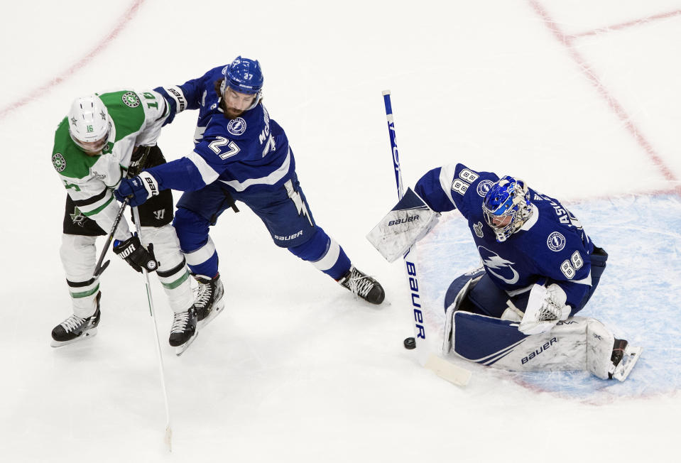 Dallas Stars' Joe Pavelski (16) and Tampa Bay Lightning's Ryan McDonagh (27) battle as Lightning goalie Andrei Vasilevskiy (88) makes a save during first-period NHL Stanley Cup finals hockey action in Edmonton, Alberta, Monday, Sept. 21, 2020. (Jason Franson/The Canadian Press via AP)