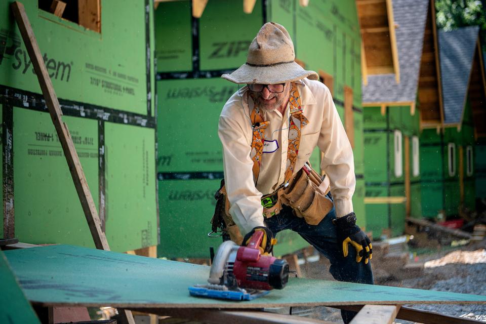 Jeff Dektor prepares a board as he volunteers at the BeLoved Asheville tiny home village July 13, 2023.