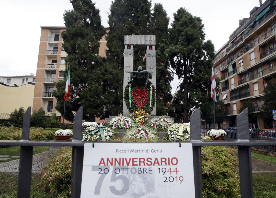 Flowers lie in front of a bronze ossuary monument entitled 'Ecco La Guerra', (Here is War) dedicated to the 'Little Martyrs of Gorla', in memory of a World War II bombing raid on Oct. 20 1944 is pictured in Milan, Italy, Sunday, Oct. 20, 2019. Milan's mayor Giuseppe Sala, following a Mass Sunday for the 75th anniversary of the raid, asked U.S. authorities to apologize for a World War II bombing raid that killed 184 elementary school children. (AP Photo/Luca Bruno)