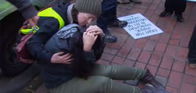 Protester is treated by ambulance staff after hitting her head on a parked car during a clash with police at Abbotsford this morning. Photo: 7News