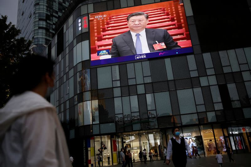Screen shows news footage of Chinese President Xi Jinping at the closing session of NPC in Beijing