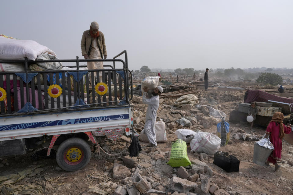 Afghans load their belongings in a vehicle after retrieving them from their damaged mud homes demolished by authorities during a crackdown against an illegal settlement and immigrants, on the outskirts of Islamabad, Pakistan, Wednesday, Nov. 1, 2023. (AP Photo/Anjum Naveed)