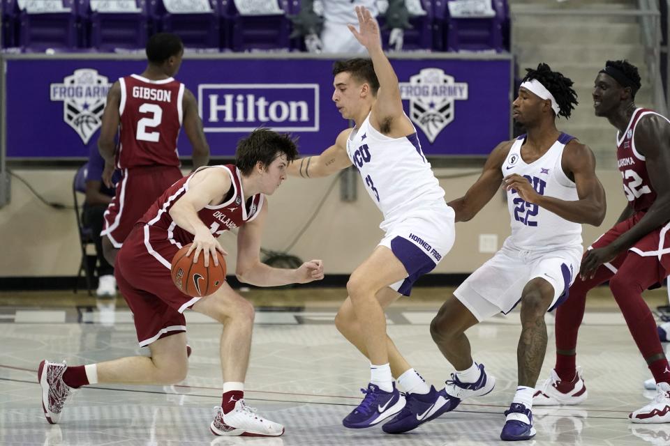 Oklahoma guard Austin Reaves (12) handles the ball as TCU's Francisco Farabello, center, of Argentina, and RJ Nembhard (22) defend in the second half of an NCAA college basketball game in Fort Worth, Texas, Sunday, Dec. 6, 2020. (AP Photo/Tony Gutierrez)