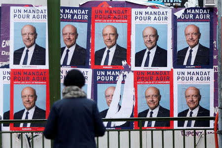 Campaign posters for Alain Juppe, member of the conservative Les Republicains political party, are seen at the entrance of a metro station in Paris as he campaigns in the second round of the French center-right presidential primary election, France, November 25, 2016. REUTERS/Charles Platiau