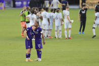 Orlando City forward Chris Mueller (9) and forward Nani (17) hug as the New England Revolution celebrate after an MLS playoff soccer match, Sunday, Nov. 29, 2020, in Orlando, Fla. (AP Photo/Matt Stamey)