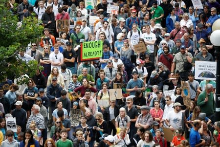 A marcher holds a sign reading "Enough already!" at Seattle City Hall during a Climate Strike march in Seattle