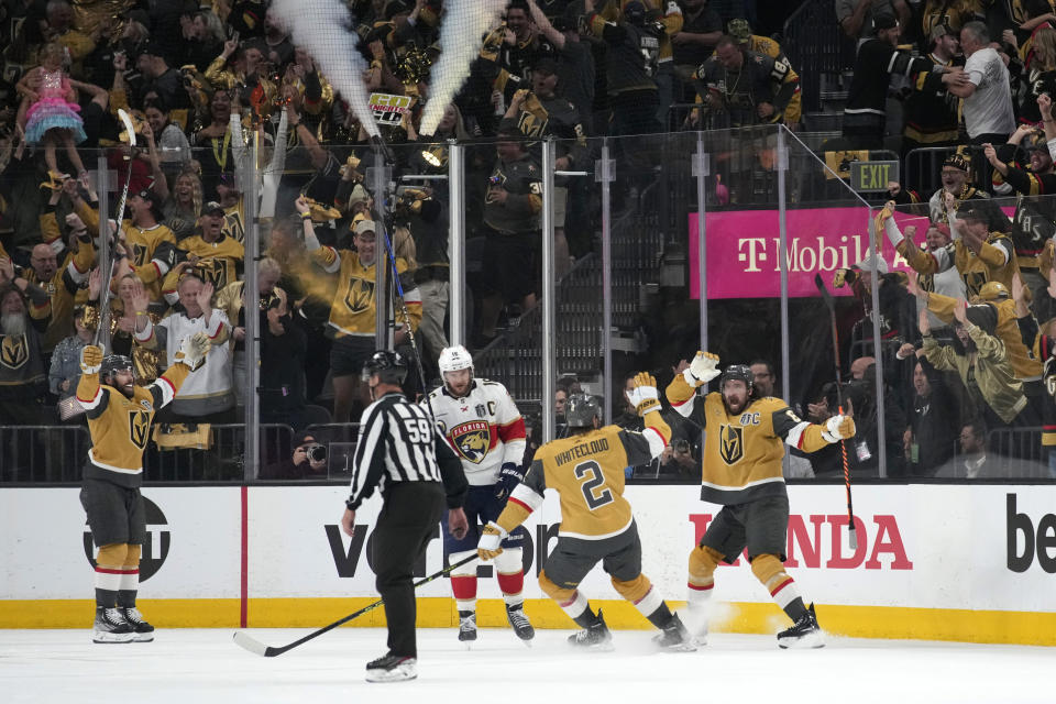 Vegas Golden Knights right wing Mark Stone, right, celebrates with defenseman Zach Whitecloud, second from right, after scoring as Florida Panthers center Aleksander Barkov skates away during the first period in Game 5 of the NHL hockey Stanley Cup Finals Tuesday, June 13, 2023, in Las Vegas. (AP Photo/John Locher)