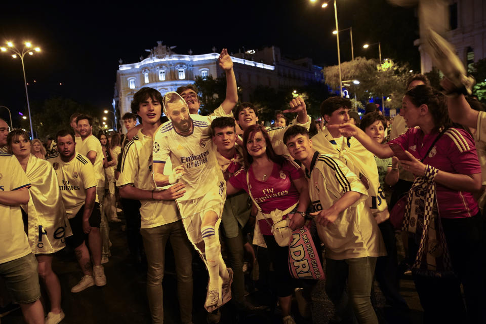 Real Madrid supporters celebrate with a figure of Real Madrid's Karim Benzema at the end of the Champions League soccer final in Cibeles square in downtown Madrid, Spain, Sunday, May 29, 2022. Real Madrid beat Liverpool 1-0 in the Champions League final in Paris. (AP Photo/Andrea Comas)